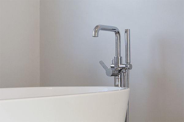 Badkamer met vrijstaand bad en moderne kraan in nieuwbouwwoning in Koolskamp.