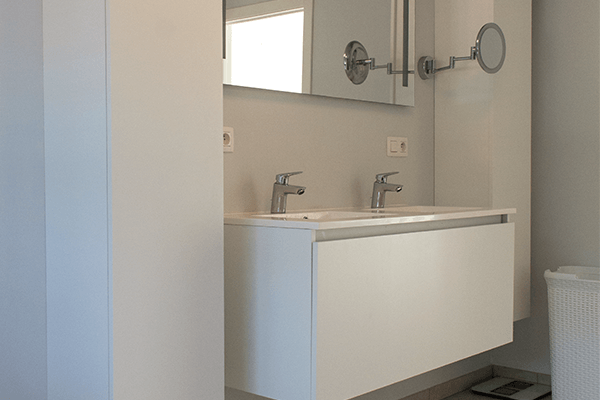 Badkamer met dubbele wastafel en spiegel in moderne gezinswoning in Koolskamp.
